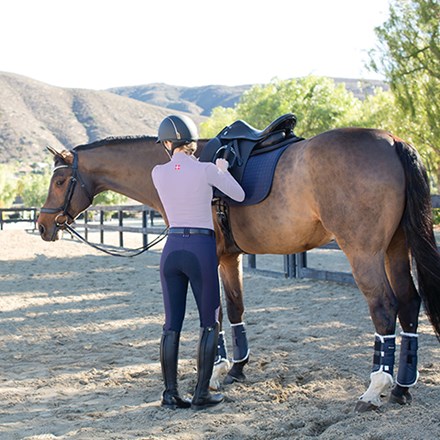 Rider running up stirrups after getting off her horse.